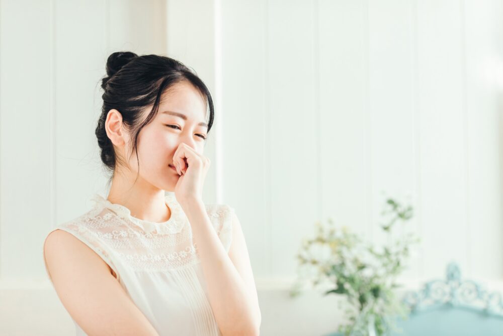 鼻を抑える女性
