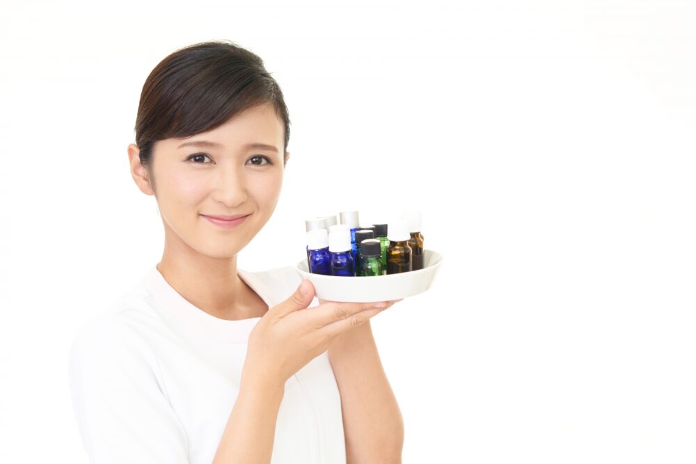 たくさんの精油を持つセラピスト